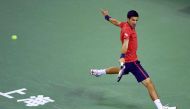 Novak Djokovic of Serbia hits a return against Fabio Fognini of Italy during their men's singles match at the Shanghai Masters tennis tournament in Shanghai on October 11, 2016. / AFP / WANG ZHAO