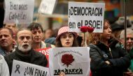 Supporters of Spain's Socialist party (PSOE) hold red roses and posters reading 