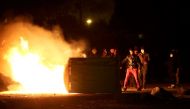 Flames are seen near protesters on the eve of the evacuation and transfer of migrants to reception centers in France, and the dismantlement of the camp called the 