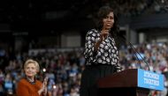 Democratic presidential nominee former Secretary of State Hillary Clinton (L) looks on as First Lady Michelle Obama speaks during a campaign rally at Wake Forest University on October 27, 2016 in Winston-Salem, North Carolina. With less than two weeks to 