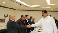 Venezuela's President Nicolas Maduro (R) shakes hands with Jesus Torrealba (L), secretary of Venezuela's coalition of opposition parties (MUD), during a political meeting between government and opposition, in Caracas, Venezuela October 30, 2016. Miraflore