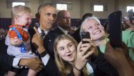 US President Barack Obama holds 10-month-old Brooks Breitwieser as he greets supporters after speaking to an overflow room during a Hillary for America campaign event for Democratic Presidential nominee Hillary Clinton at the Capital University Field Hous