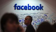 People pass by the stand of Facebook during the Web Summit at Parque das Nacoes, in Lisbon on November 9, 2016. AFP / PATRICIA DE MELO MOREIRA
