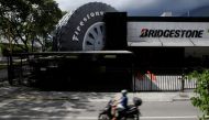 A motorcyclist ride past a Bridgestone Firestone tires store in Caracas, Venezuela November 5, 2016. REUTERS/Marco Bello