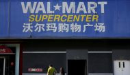 Pedestrians walk past a signboard of Wal-Mart at its branch store in Beijing, October 15, 2015 (REUTERS / Kim Kyung-Hoon) 