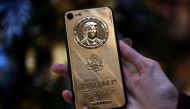 REPRESENTATIVE IMAGE: An employee of Caviar Phones, a Russian-Italian company specializing in smartphone customization, displays a special gold-plated iPhone 7 smartphone bearing the likeness of US President-elect Donald Trump - at a minimum price of 197 