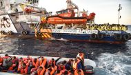 This file photo taken on November 5, 2016 shows members of Maltese NGO MOAS helping people to board a small rescue boat during a rescue operation of migrants and refugees by the Topaz Responder ship run by Moas and the Red Cross, on November 5, 2016 off t