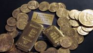(FILES) This file photo taken on October 05, 2012 shows Gold bars and coins displayed on a table at the Comptoir National de l'Or, a shop that buys, sales and estimates gold and jewellery in Paris. AFP / BERTRAND GUAY
