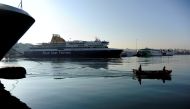 A boat passes by moored passenger ships during a 24-hour strike by Greek ship workers against government policies affecting their sector at the port of Piraeus, near Athens, Greece, November 24, 2016. REUTERS/Michalis Karagiannis