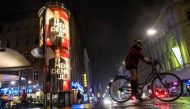 A woman cycles past posters of presidential candidate Alexander Van den Bellen,independent candidate and the former chief of the Green party in Vienna, Austria on November 26, 2016. AFP / JOE KLAMAR