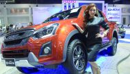 A Thai model poses next to a Isuzu D-MAX pickup truck during the Motor Expo 2016 in Bangkok on December 1, 2016. / AFP / TANG CHHIN SOTHY