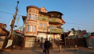A man walks next to a house decorated with party flags in Suto Orizari, a district with Europe's largest Roma communities, Macedonia, December 7, 2016. Picture taken December 7, 2016. Thomson Reuters Foundation/Ognen Teofilovski