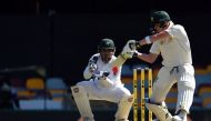 Australia's batsman Steven Smith plays a shot as Pakistan's wicketkeeper Sarfraz Ahmed looks on during the first day-night cricket Test between Australia and Pakistan at Gabba stadium in Brisbane on December 15, 2016. (AFP / SAEED KHAN)