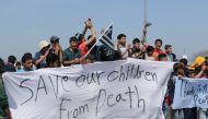 Refugees hold banners and block the highway which connects Greece and Macedonia as they stage a protesin the Idomeni town of Greece on April 5, 2016 (Anadolu Agency / Besar Ademi) 
