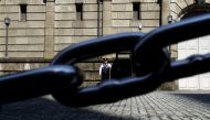 A security officer is seen through a chain link as he stands guard outside the Bank of Japan headquarters in Tokyo, March 31, 2016 (REUTERS / Yuya Shino) 
