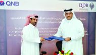 Khaled Al Nuaimi (left), AGM of SMEs at QNB, and Khalid Abdulla Al Mana, Executive Director of Business Finance at Qatar Development Bank (QDB), exchanging documents after the signing ceremony on Monday. Pic: Kammutty VP/The Peninsula