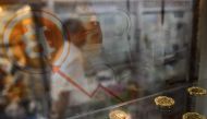 This file photo taken on August 3, 2016 shows a man walking past a display cabinet containing models of Bitcoins in Hong Kong. Bitcoin neared its all-time high on January 5, 2017 with the surging digital currency tipped to become a new safe haven asset as