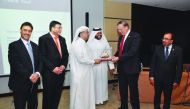 A IIA Qatar Chapter official presenting a memento to IIA Global President Richard F Chambers, in Doha. 
