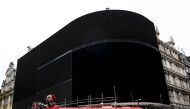 A double decker bus passes the advertisement boards at Piccadilly Circus which have been switched off prior to being replaced with more modern screens, in central London, Britain January 16, 2017. REUTERS/Stefan Wermuth,
