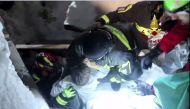 A handout picture released on January 20, 2017 by the Vigili del Fuoco shows a child (C) being rescued from the Hotel Rigopiano, near the village of Farindola, on the eastern lower slopes of the Gran Sasso mountain, engulfed by a powerful avalanche a day 