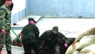 Soldiers jump into a hole to inspect a 250kg World War II bomb that was found during excavation works at a gas station in Thessaloniki, Greece, yesterday. Authorities are making arrangements to evacuate about 75,000 people ahead of efforts to defuse the b