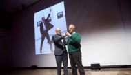 Winner of the World Press Photo 2016 photographer Burhan Ozbilici (R) and Managing Director of the World Press Photo Foundation Lars Boering, speak on stage during the announcement of the World Press Photo prizes in Amsterdam, on February 13, 2017.  AFP /