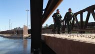 US Border Patrol agents walk over a canal of water flowing into Mexico at the US Mexico border fence on November 17, 2016 in San Luis, Arizona (John Moore / Getty Images / AFP) 