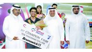 Jassim Al Muraikhi of Qatar, winner in the Emir Cup 2017, poses for a picture along with the winner's cheque and bowling officials on Sunday at the Qatar Bowling Center in Doha.