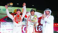 Qatar's Nasser Saleh Al Attiyah (centre) and his French navigator Matthieu Baumel, winners of the inaugural Dubai International Baja, pose for a photograph with Mohammed Ben Sulayem, President Emirates Motorsport Federation (right) during the presentation