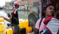 A man waits for his jerrycan to be filled at a public fountain during a period when the public water supply has been cut off, in the Isotry district of Antananarivo, Madagascar on March 17, 2017. 
/ AFP / RIJASOLO