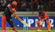 (FILES) This file photo taken on April 18, 2017 shows Royal Challengers Bangalore cricketer Chris Gayle (L) being watched by Gujarat Lions wicketeeper Dinesh Karthik during the 2017 Indian Premier League (IPL) Twenty20 cricket match between Gujarat Lions 