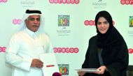 Chief Operating Officer of Ooredoo, Yousuf Abdulla Al Kubaisi (left), exchanges documents with Executive Director of Best Buddies Qatar, Laalei Abu Alfain, after the signing ceremony at Ooredoo Headquarters yesterday. 
Pic: Kammutty VP / The Peninsula