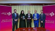 Commercial Bank officials pose for a group photo with the awards at the bank's headquarters in Doha.