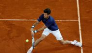 Djokovic returns the ball. REUTERS/Susana Vera
