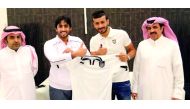Qatari international defender Khoukhi Boualem (third left) poses for a photograph, holding the Al Sadd jersey with club officials after signing a two-year deal with the Emir Cup champions on Monday.  LEFT: Al Sadd's Algerian striker Baghdad Bounedjah sign