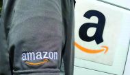 A file photo of an Amazon.com Inc driver stands next to an Amazon delivery truck in Los Angeles, California, US.