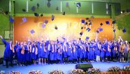 Graduates tossing hats in air during the graduation ceremony at ISL Qatar. 