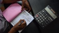 An Indian shopkeeper prepares a bill for a customer at his shop in New Delhi (AFP / SAJJAD HUSSAIN) 
