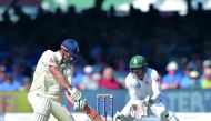 England's Alastair Cook (left) bats as South Africa's Quinton de Kock looks on during the third day of the first Test match at Lord's Cricket Ground in central London. 