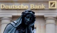 A statue is seen next to the logo of Germanys Deutsche Bank in Frankfurt (REUTERS / Kai Pfaffenbach) 