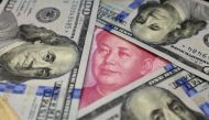 Benjamin Franklin US 100 dollar banknotes and a Chinese 100 yuan banknote with the late Chinese Chairman Mao Zedong are seen in this January 21, 2016 picture illustration.  (REUTERS / Jason Lee) 