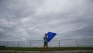 A man uses a kayak sail to propel himself on his skateboard ahead of the arrival of Hurricane Irma in Tampa, Florida, U.S., September 9, 2017. Reuters/Chris Wattie