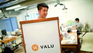 Employees work at the company office running Valu, a web-based virtual exchange in Tokyo, Japan.