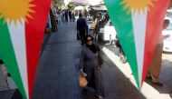 A woman walks on the street, between banners supporting the referendum for independence of Kurdistan in Erbil, Iraq September 24, 2017. REUTERS/Alaa Al-Marjani