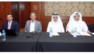 Ahmed Mohammed Al Shaabi (second right), Executive Director of the Common Services Sector at QCB, and Bahij Naji Al Khatib (second left), Director of the Training Department of the Union of Arab Banks, along with other officials, discussing the provisions