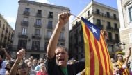 A man waves a stelada (pro-independence Catalan flag) during a protest against the arrest of two Catalan separatist leaders in Barcelona on October 17, 2017.  AFP / LLUIS GENE
