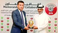 Sheikh Hamad bin Khalifa bin Ahmed Al Thani, President of Qatar Football Association (QFA) hands over a memento to Umid Ahmadjonov, President of Uzbekistan Football Federation (UFF) after signing a memorandum of collaboration at QFA’s headquarters at Al B