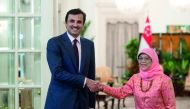 Emir H H Sheikh Tamim bin Hamad Al Thani is received by President of Singapore, Halimah Yacob, in Singapore, yesterday.