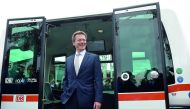 Richard Lutz, CEO of German railway company Deutsche Bahn, waves in front of the first German autonomous public transport bus during a presentation in Bad Birnbach, southern Germany, on October 25, 2017. AFP / Christof Stache