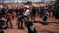 Protesters throw stones during clashes with police forces in the Kibera district, Nairobi, on October 26, 2017.  AFP / MARCO LONGARI
